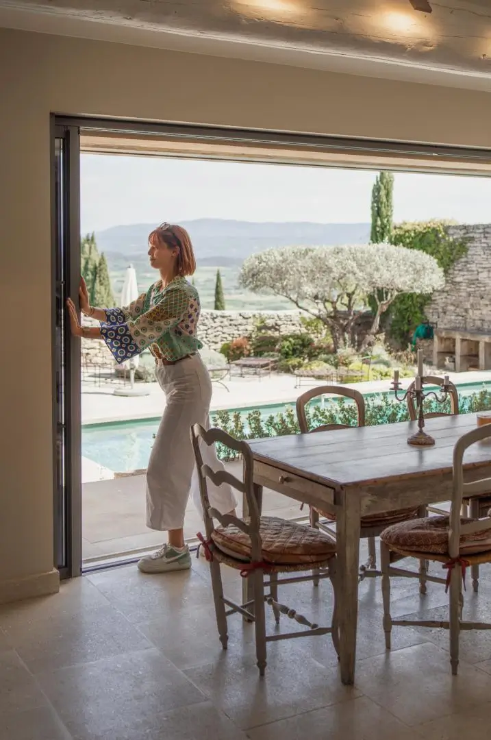 Propriétaire ouvrant sa maison secondaire sur un jardin ensoleillé – Conciergerie Pirotte, sérénité en Provence.