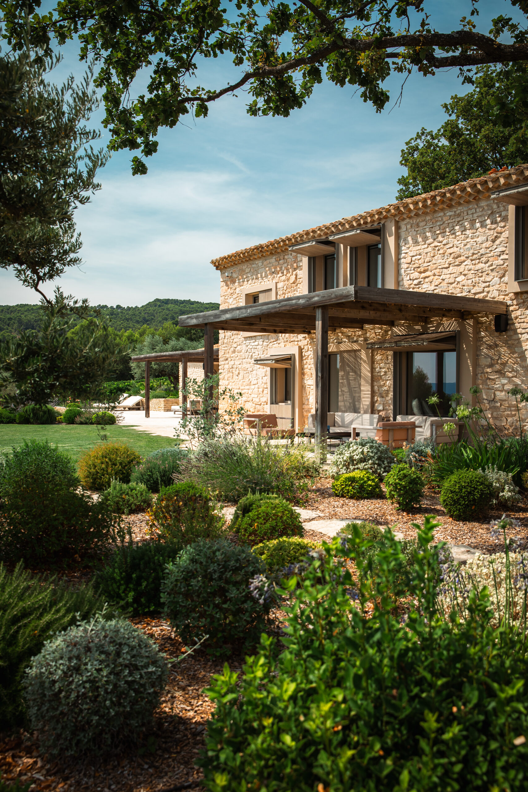 Maison provençale en pierre avec jardin et bassin, reflet du savoir-faire et du soin Pirotte en Luberon.